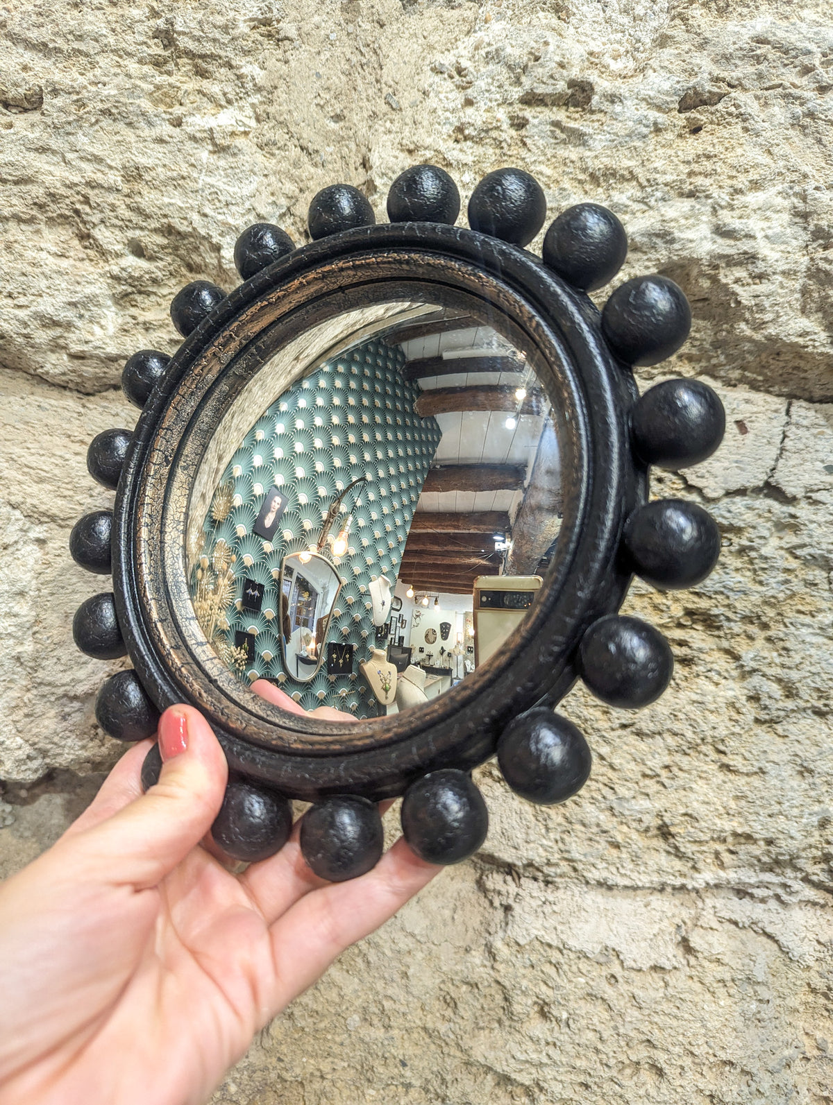 Miroir de sorcière noir à boules vu de biais, verre bombé