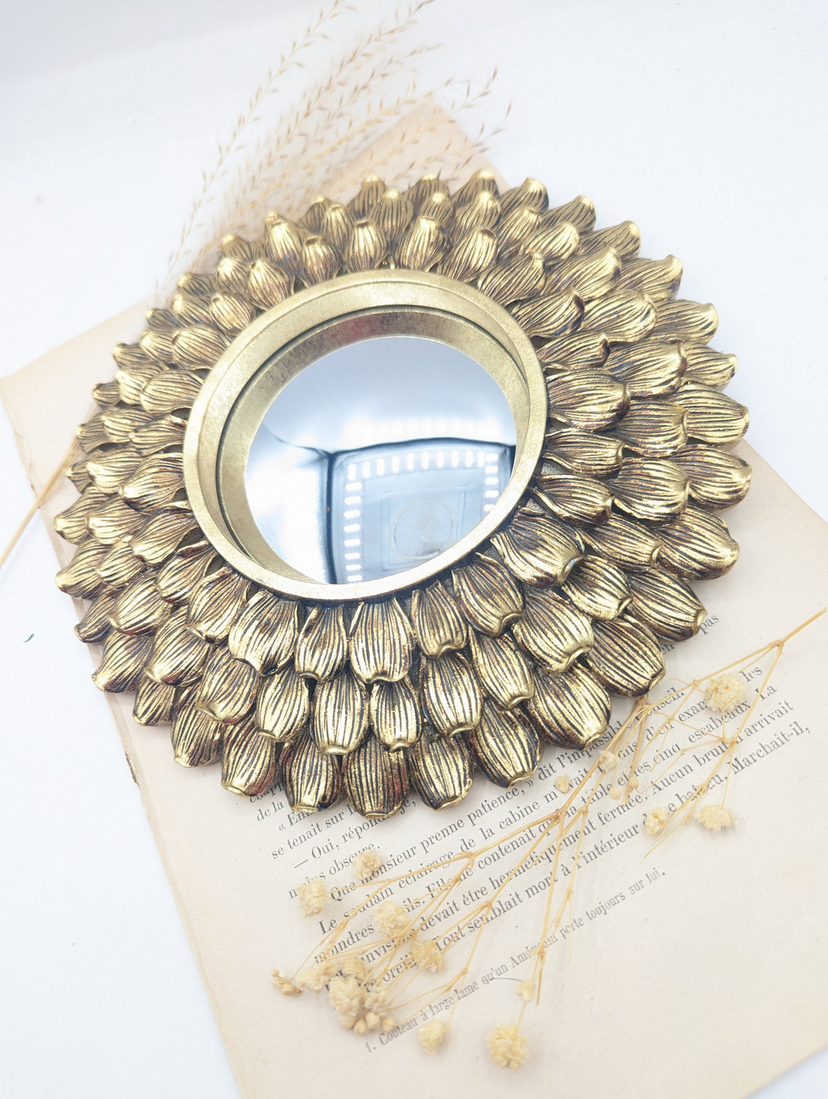 Miroir œil de sorcière à cadre pétales dorés avec fleurs séchées