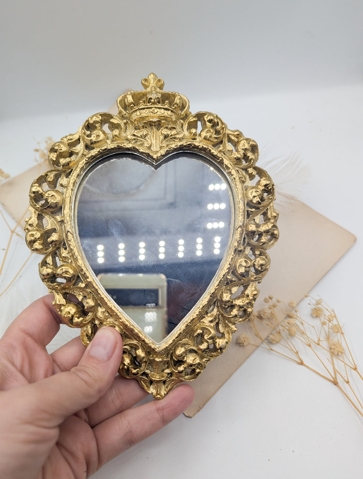 Miroir cœur sacré doré tenu en main, format 18 x 14 cm