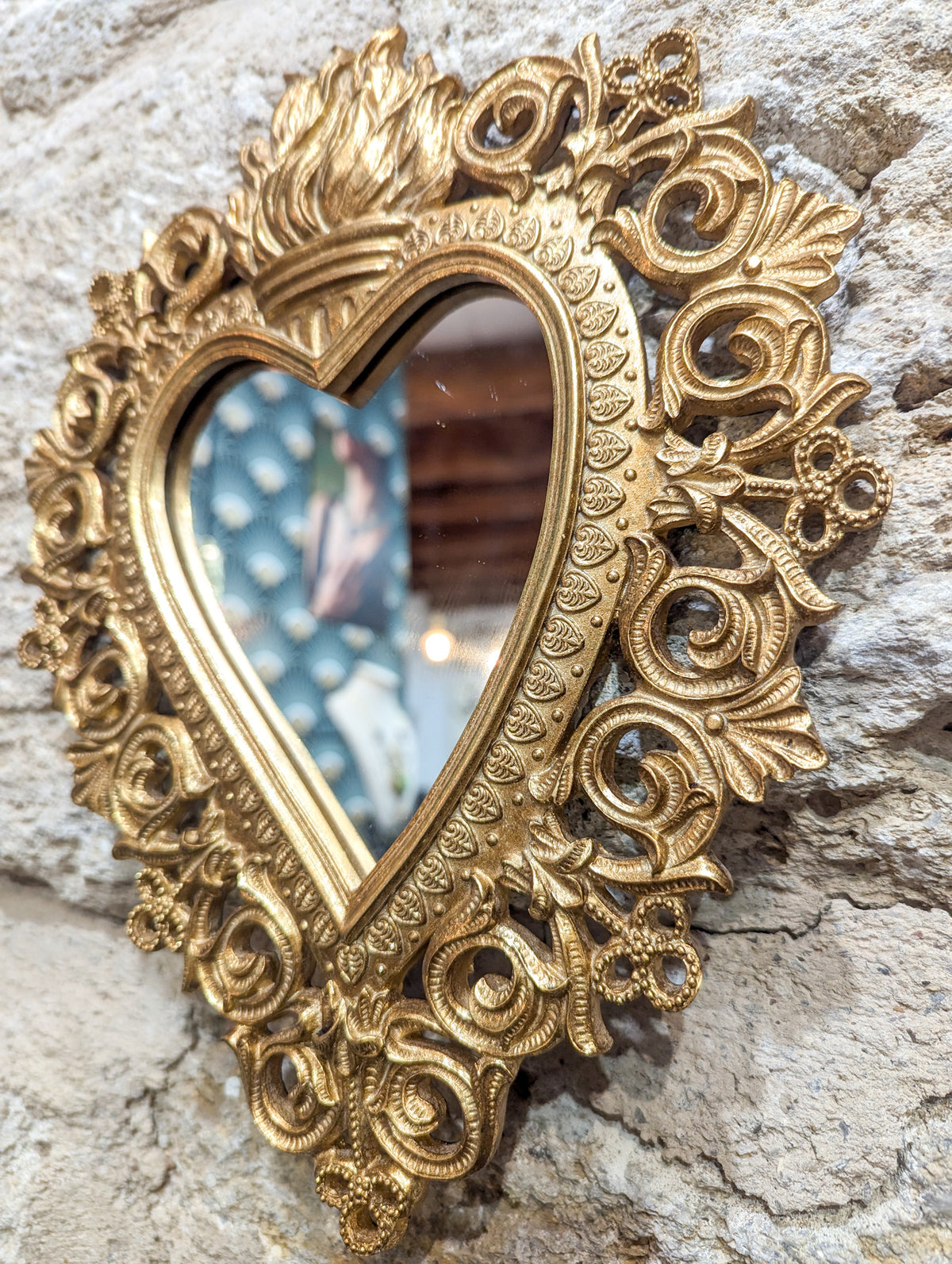 Détail du cadre en résine dorée à roses et volutes du miroir cœur sacré