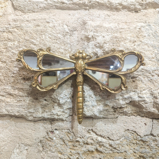 Miroir libellule accroché sur un mur en pierre
