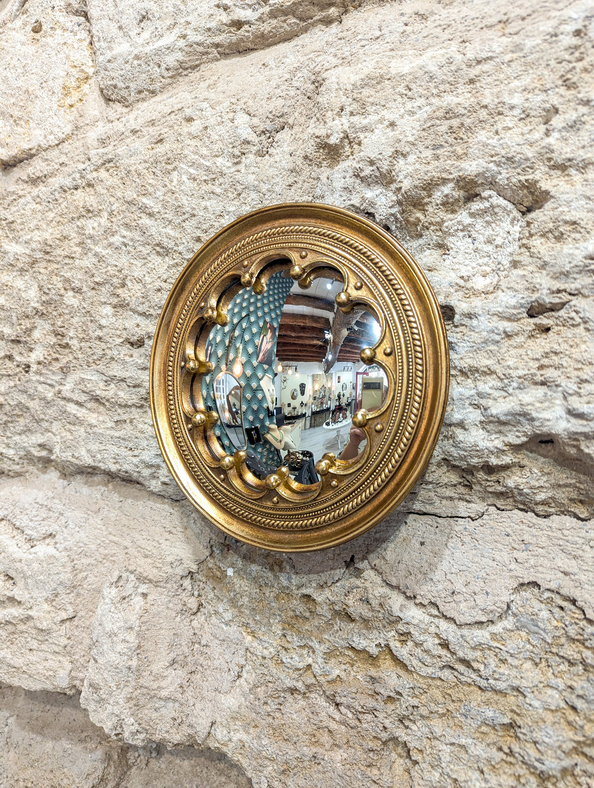 Détail du cadre en résine dorée du miroir convexe couronne