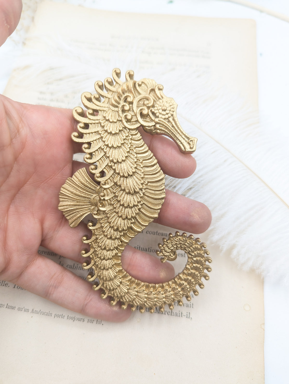 Hippocampe doré art nouveau tenu en main