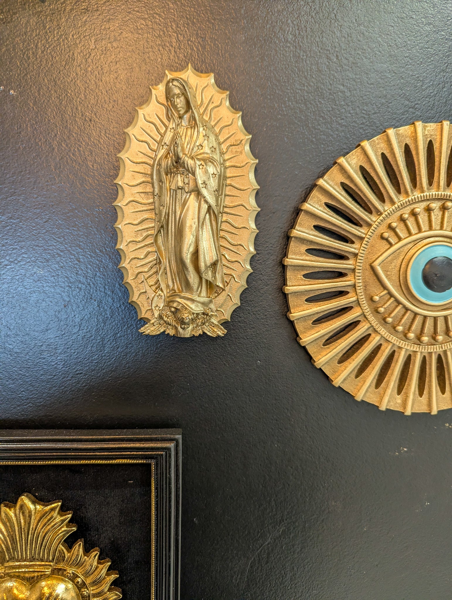 Décoration murale Vierge de Guadalupe dorée exposée avec d'autres objets pour un cabinet de curiosité