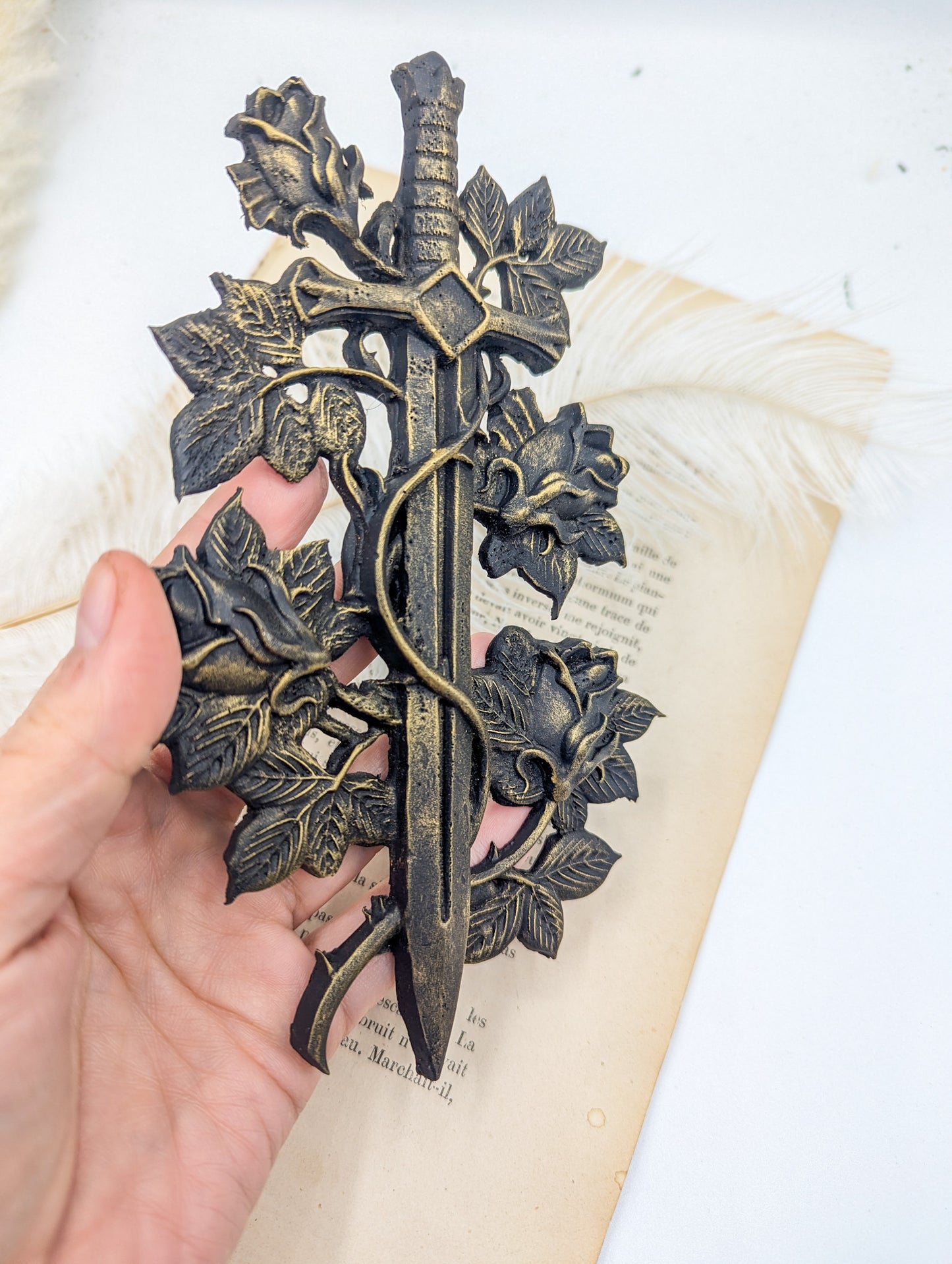 Gros plan sur les roses et épines de l'épée de chevalier noir antique – finition artisanale noire antique
