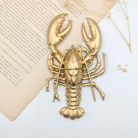 Homard doré en décoration murale style maritime bord de mer et cabinet de curiosités