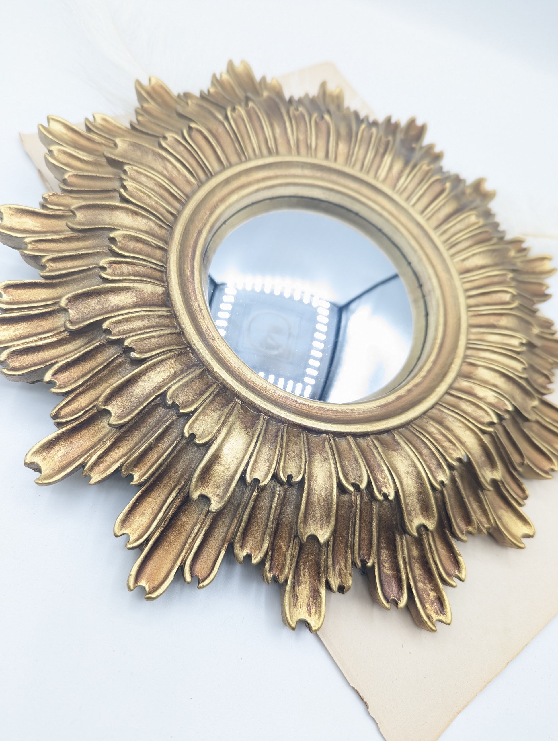 Miroir soleil convexe doré et noir en gros plan style cabinet de curiosités
